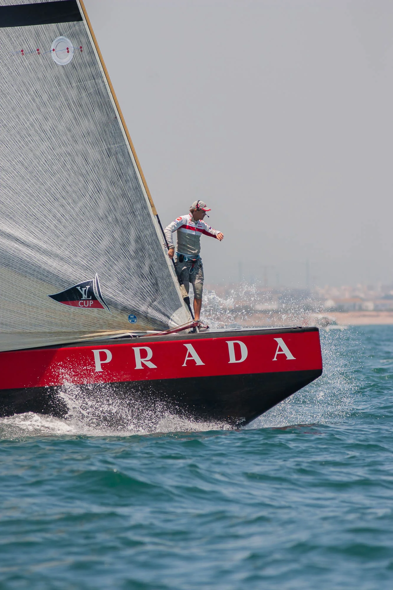Barca di Luna Rossa all'America's Cup: un velista in equilibrio sulla prua con la scritta Prada