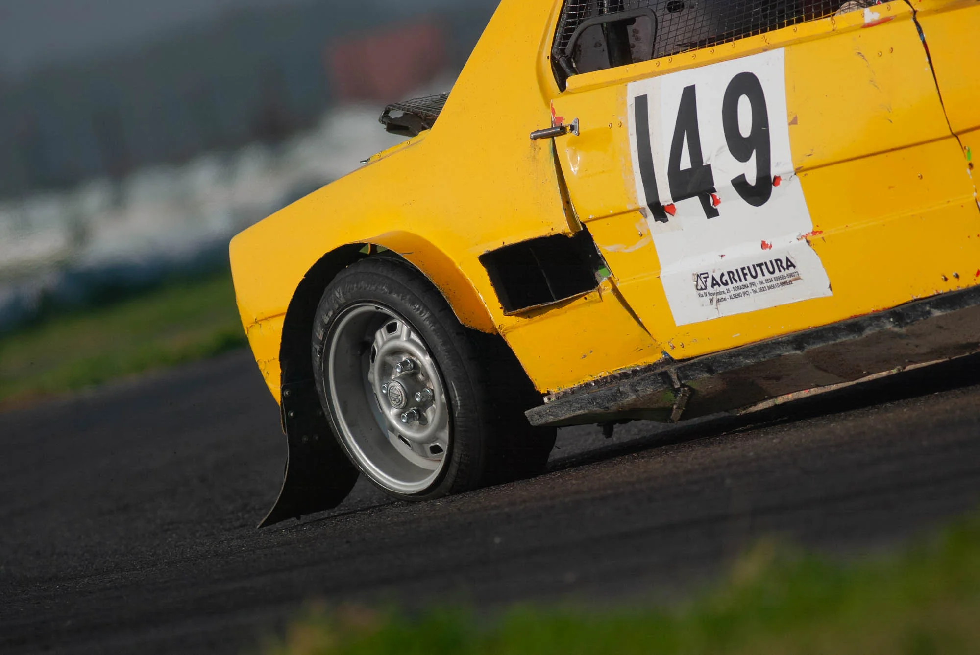 Auto da corsa gialla con il numero 149 in curva